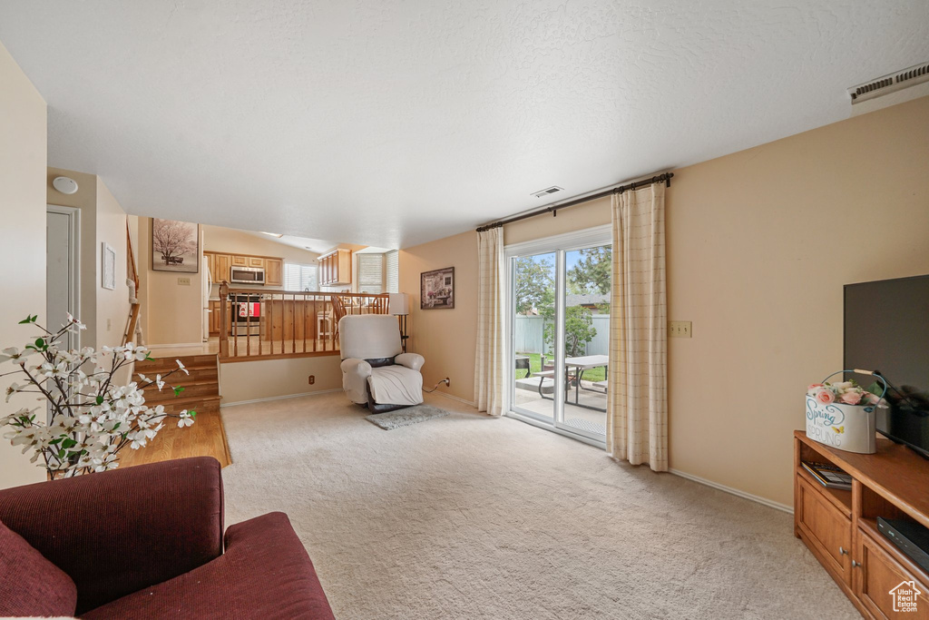 Living area featuring light carpet and baseboards