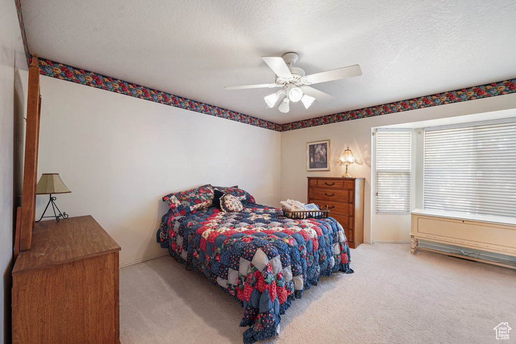 Bedroom with carpet flooring, baseboards, and ceiling fan