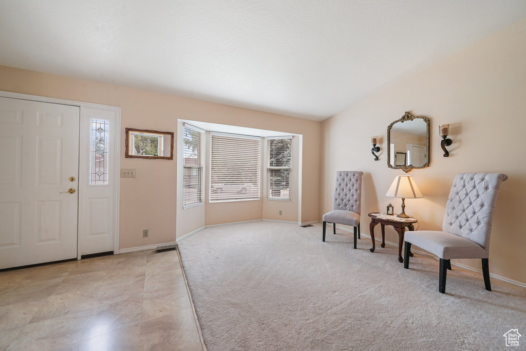Entryway with healthy amount of natural light, baseboards, and light colored carpet