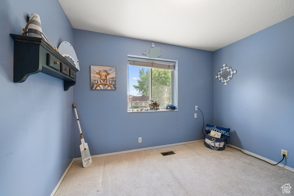 Spare room featuring carpet floors and baseboards