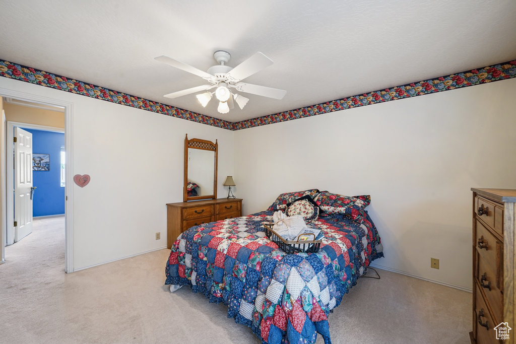 Bedroom featuring light carpet, ceiling fan, and baseboards