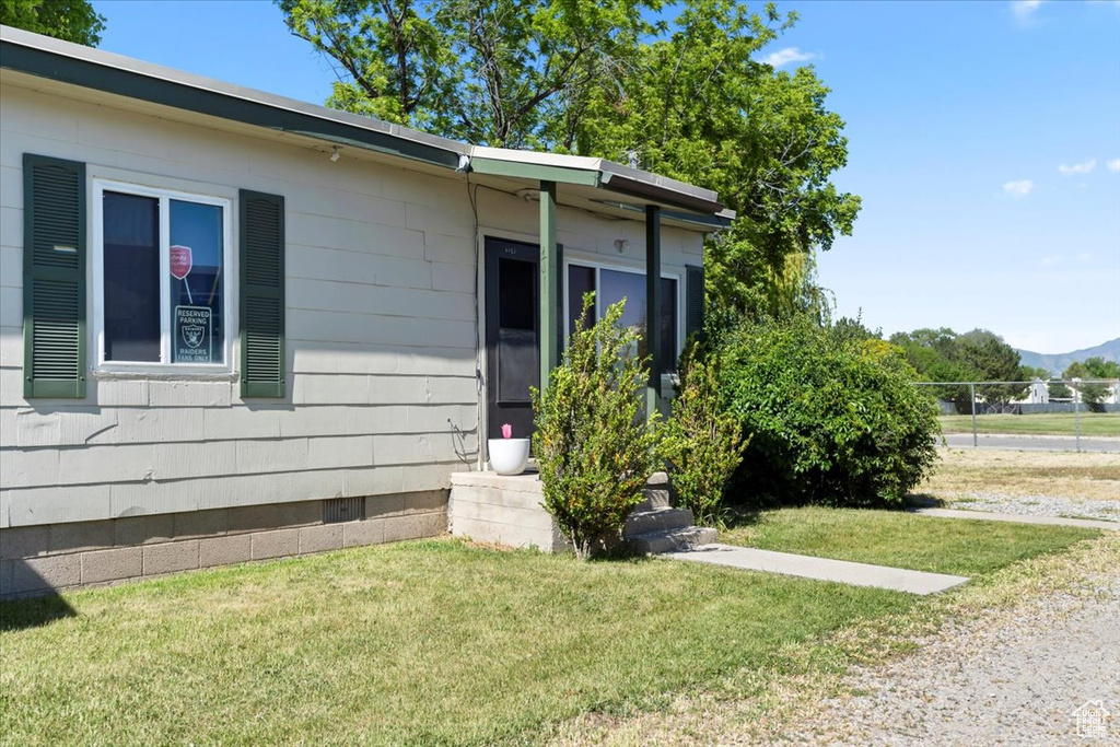 View of home's exterior featuring a lawn, a mountain view, and crawl space