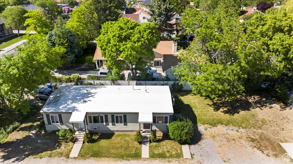 Aerial view of property and surrounding area featuring a tree filled landscape