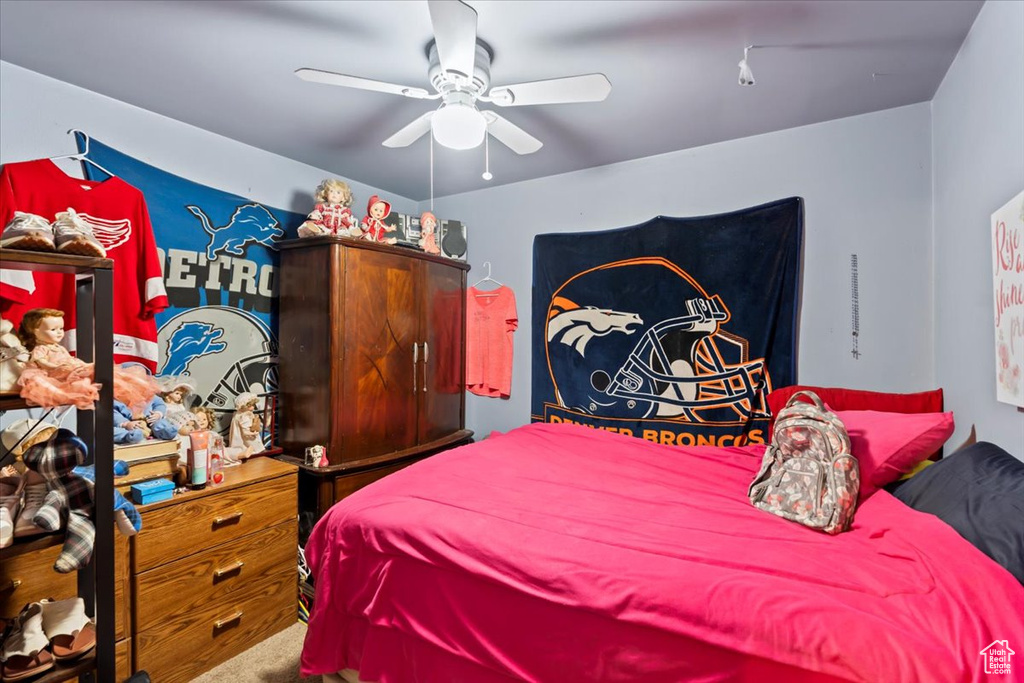 Carpeted bedroom featuring a ceiling fan