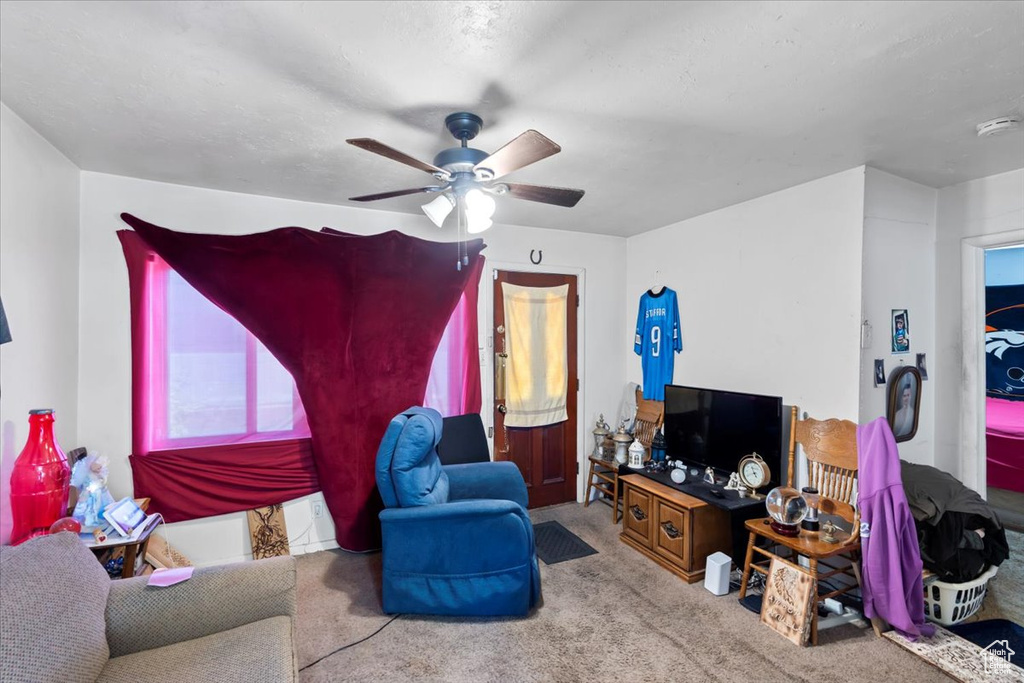 Carpeted living room featuring ceiling fan