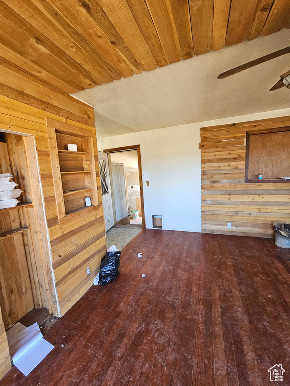 Unfurnished living room with hardwood / wood-style flooring, wood walls, and wood ceiling