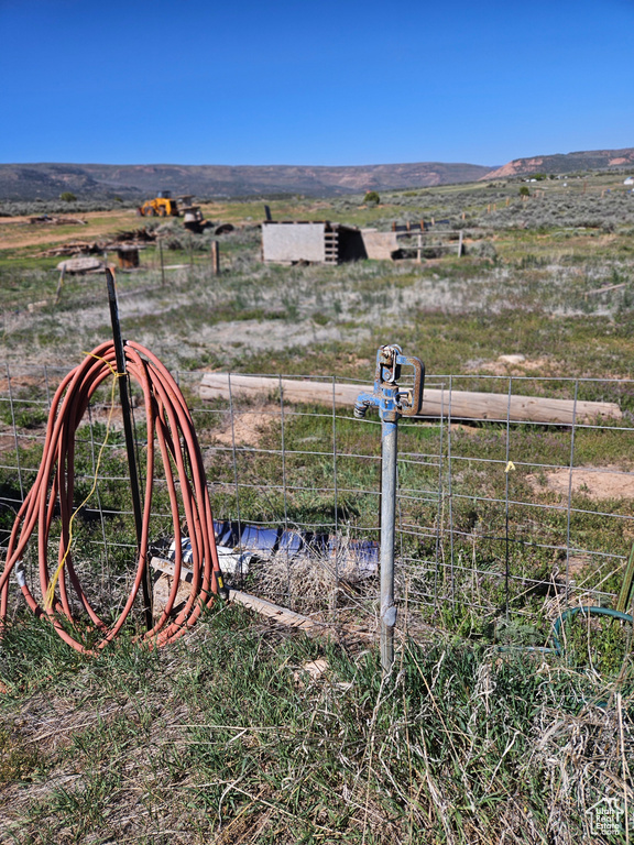 View of yard with a rural view and a mountain view