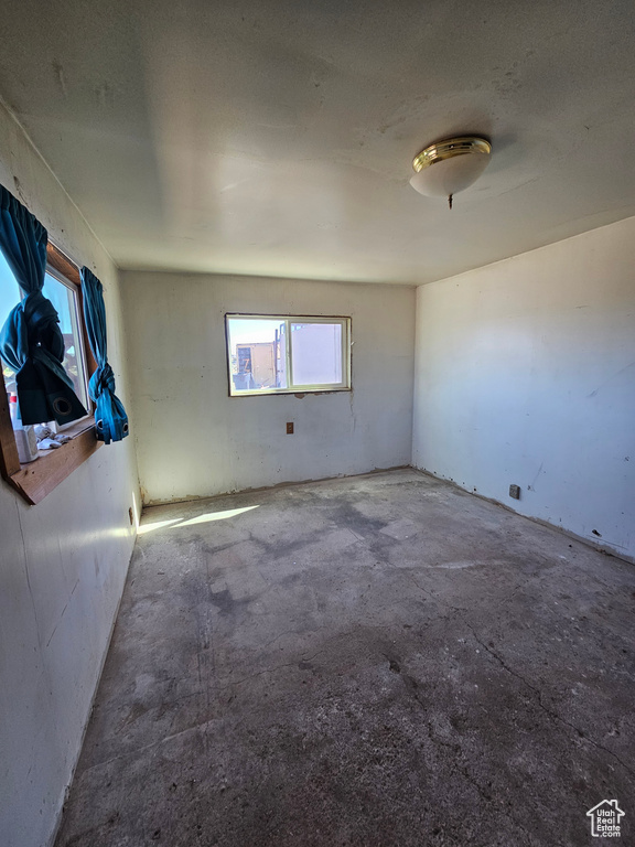Unfurnished room featuring unfinished concrete floors