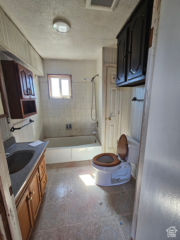 Bathroom with toilet, bathing tub / shower combination, vanity, tile patterned floors, and a textured ceiling