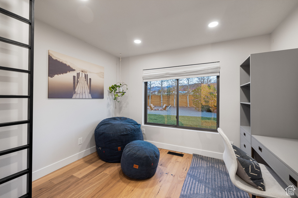 Sitting room with wood finished floors, baseboards, recessed lighting, and an office area