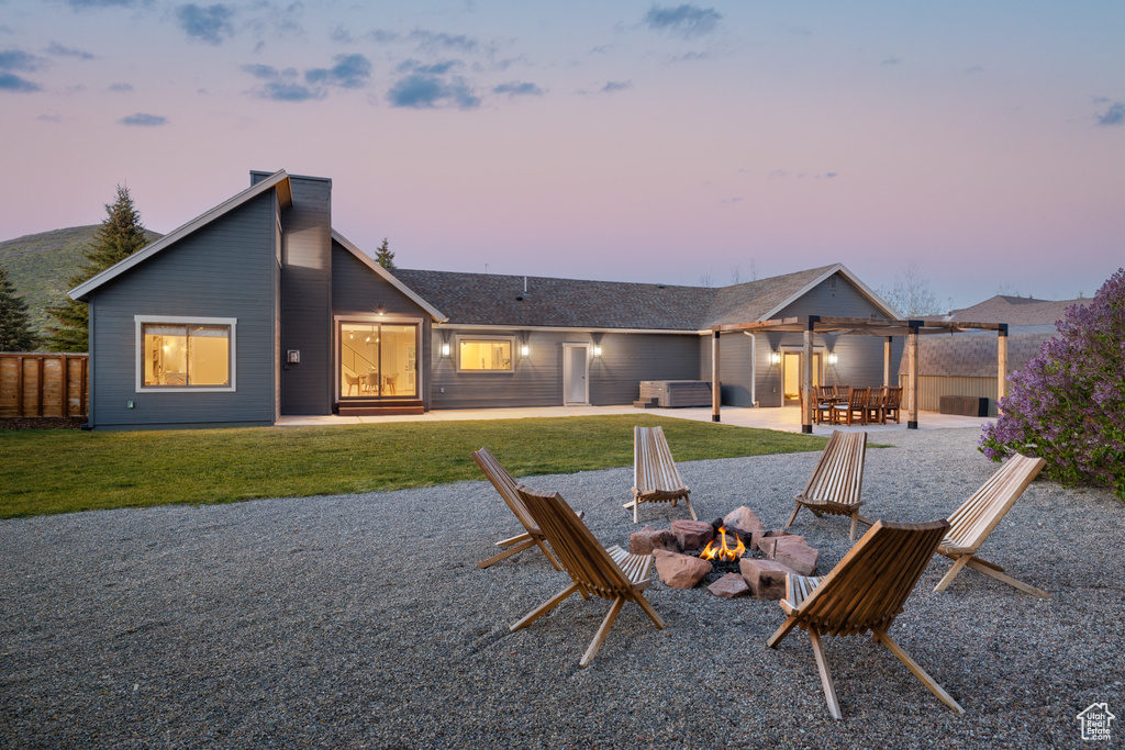 Rear view of house featuring an outdoor fire pit, a patio, a lawn, and a jacuzzi