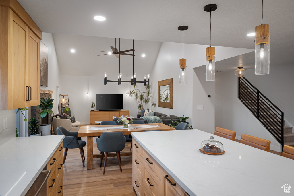 Kitchen featuring high vaulted ceiling, light wood-style floors, light stone counters, recessed lighting, and open floor plan