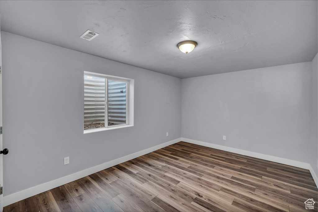 Spare room featuring baseboards and wood finished floors