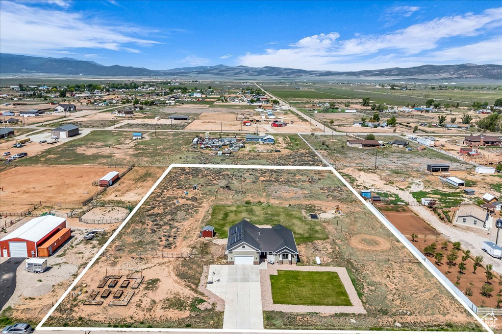 Aerial view of property and surrounding area with property boundaries highlighted and a mountain backdrop