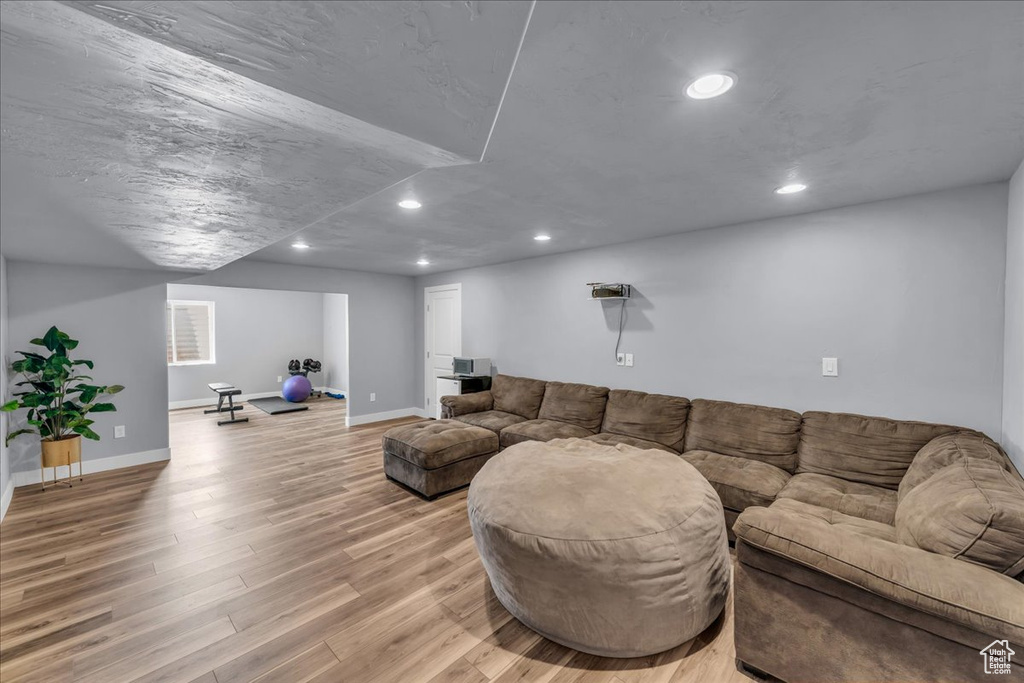 Living room with recessed lighting, light wood finished floors, and baseboards