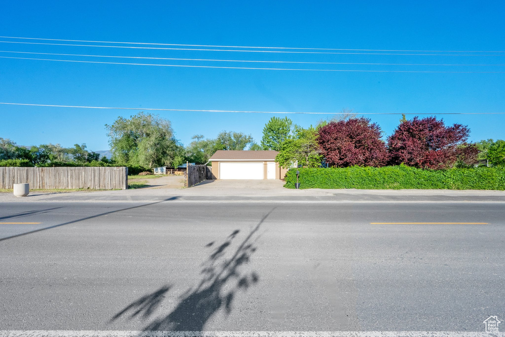 View of property hidden behind natural elements with a detached garage