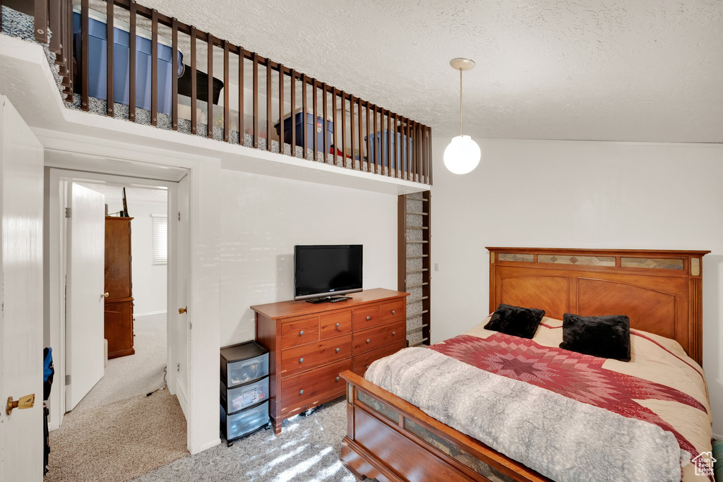 Bedroom featuring light colored carpet and a textured ceiling