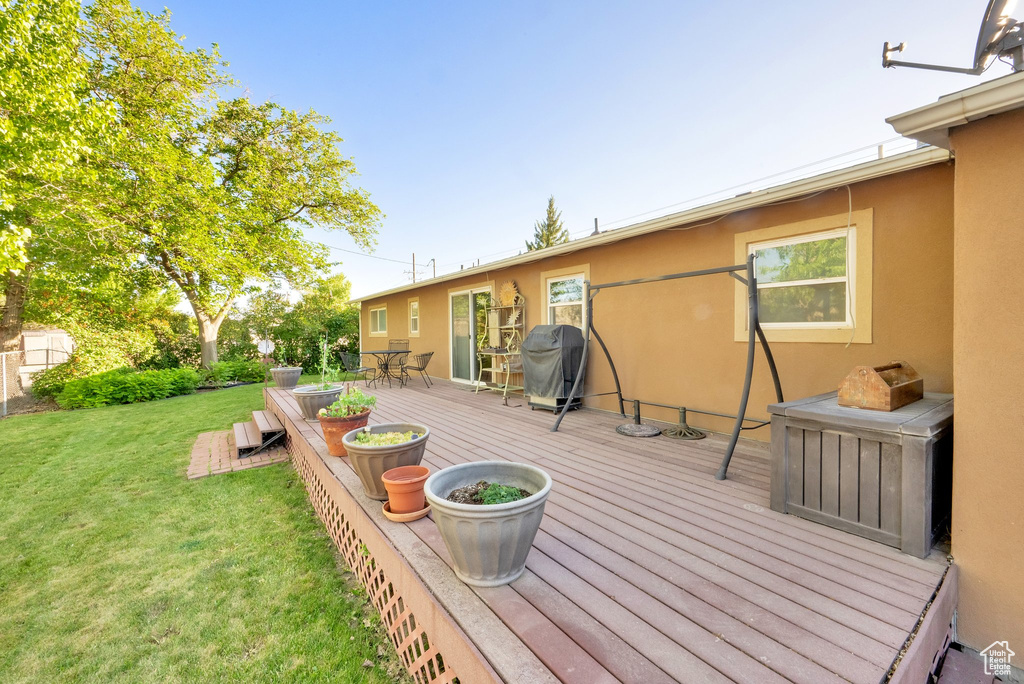 Deck featuring a yard, outdoor dining area, and a grill