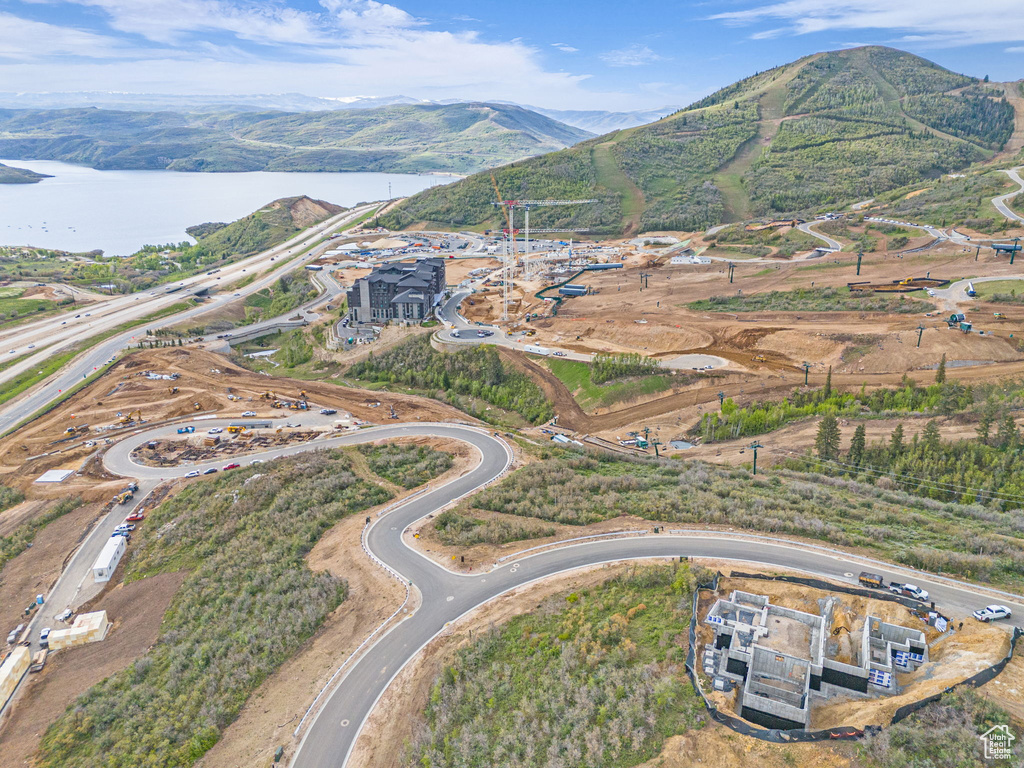 Aerial view of property and surrounding area with a water and mountain view