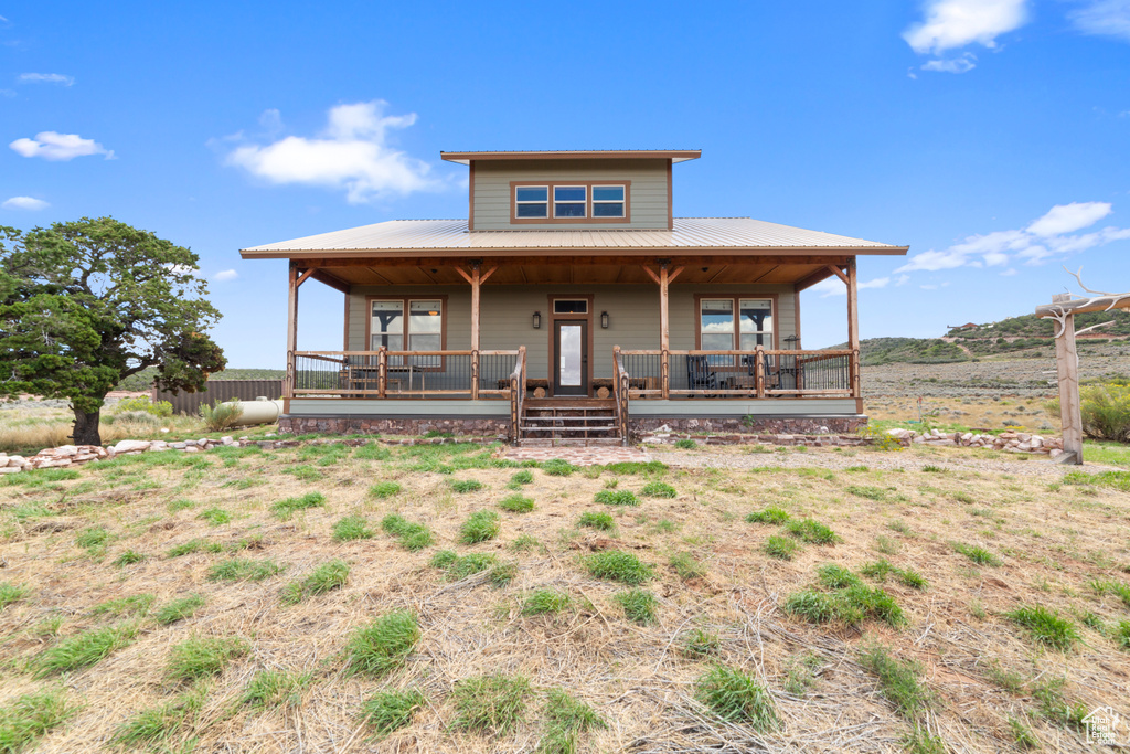 Farmhouse inspired home with covered porch and metal roof