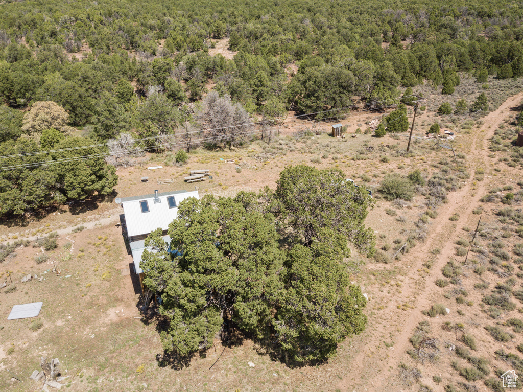 Aerial view of property and surrounding area with a heavily wooded area