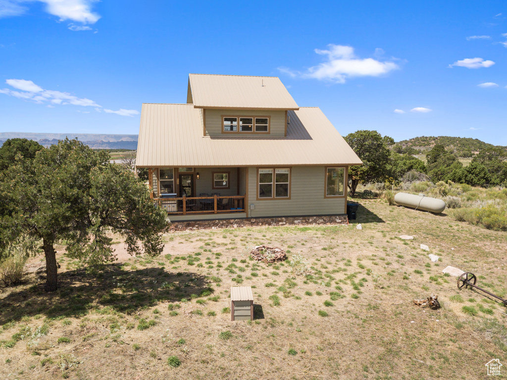 Back of property featuring metal roof and a porch