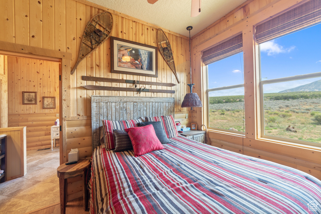 Bedroom with wood walls and a mountain view