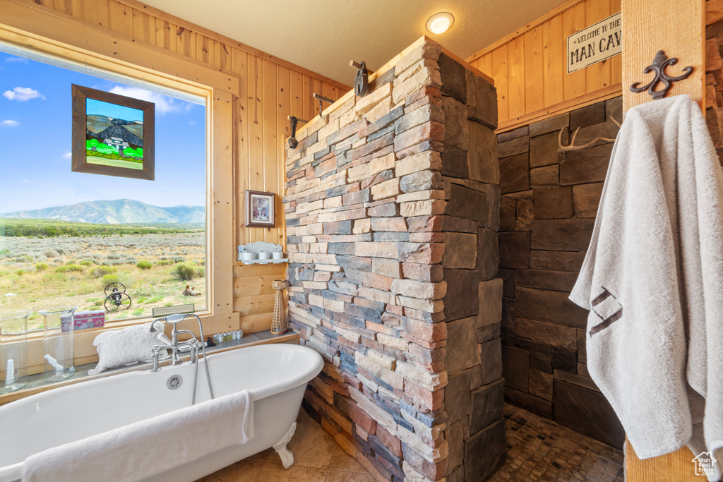 Full bath with wood walls, a freestanding tub, a mountain view, and tiled shower