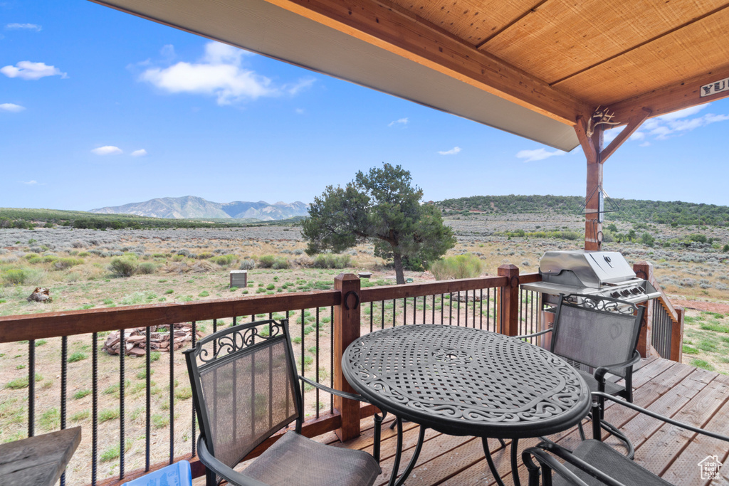 Wooden deck featuring a mountain view and outdoor dining area