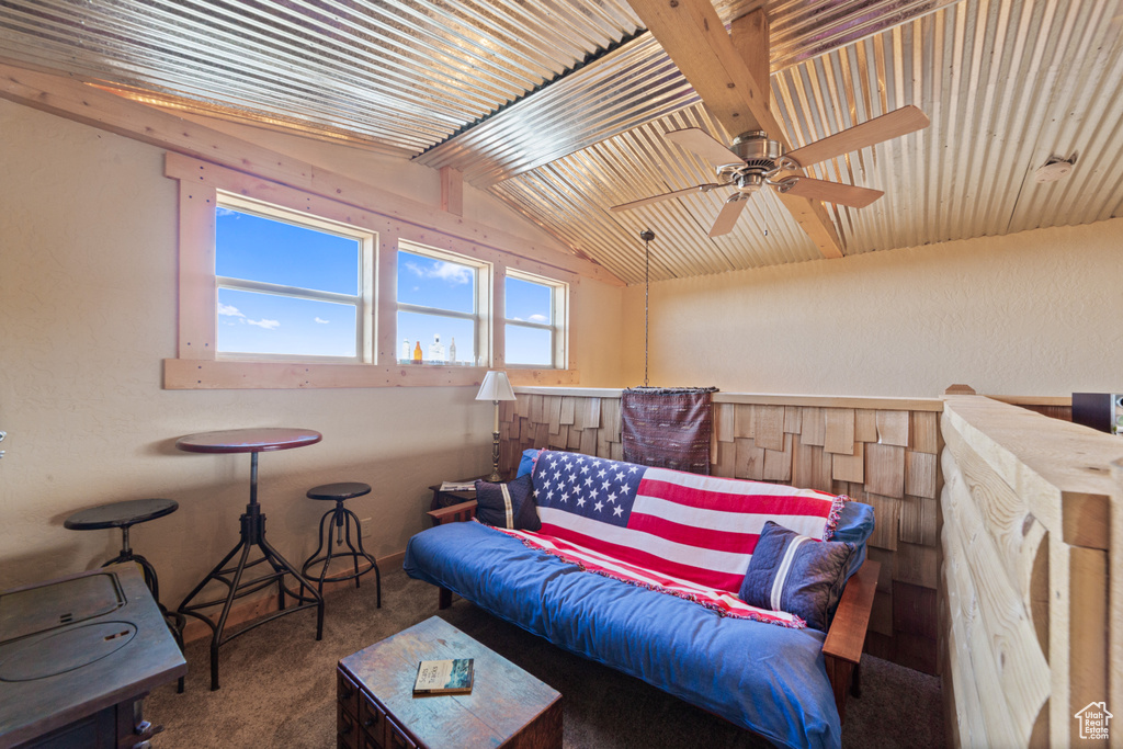 Living area featuring carpet floors, vaulted ceiling, and ceiling fan