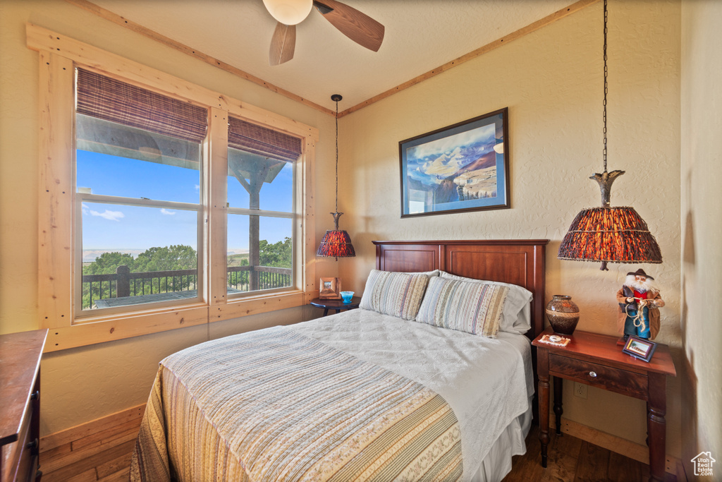Bedroom featuring a textured wall, dark wood-style flooring, and baseboards