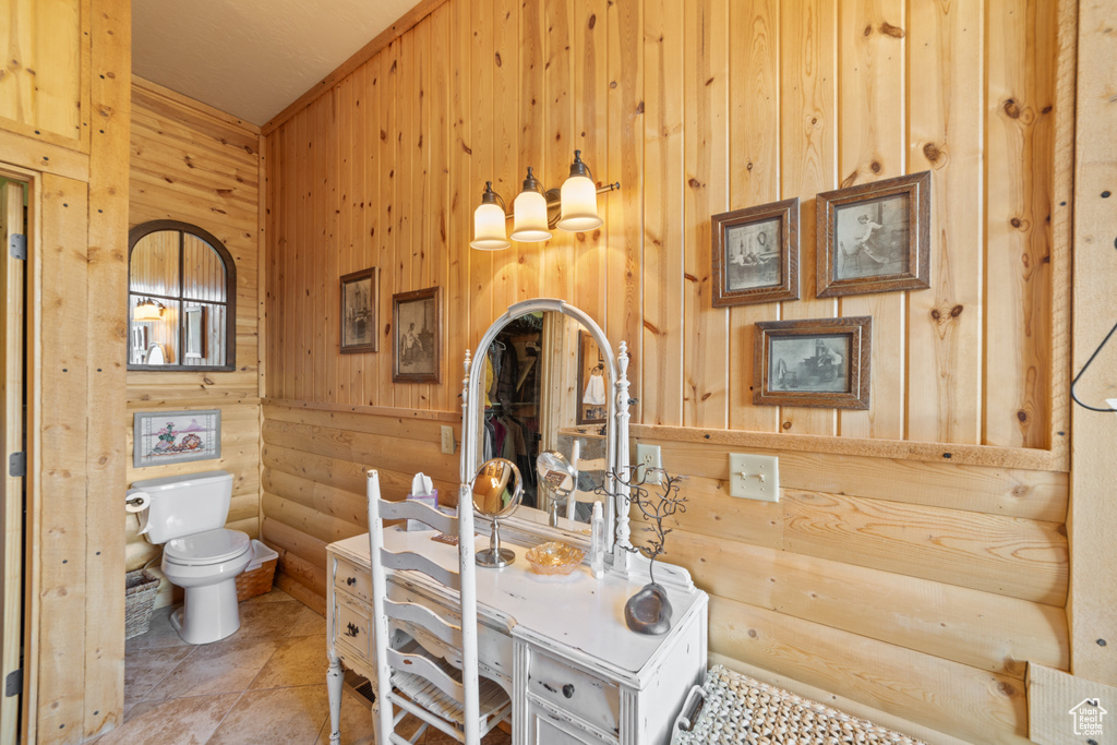 Bathroom featuring wooden walls and toilet