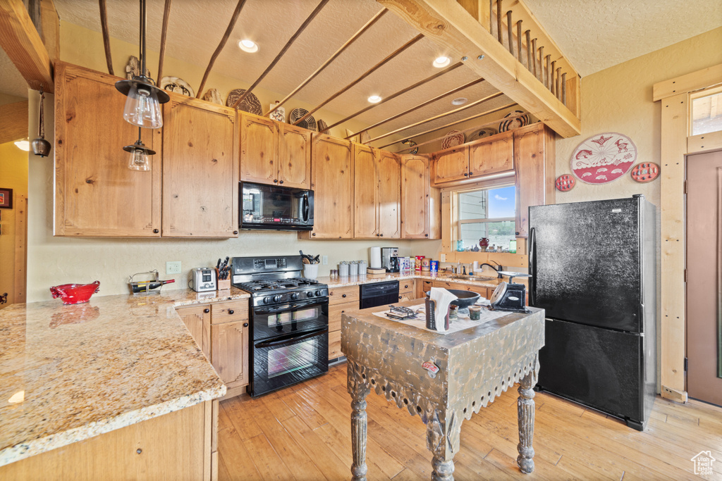 Kitchen with black appliances, light wood-style flooring, light brown cabinetry, recessed lighting, and a sink