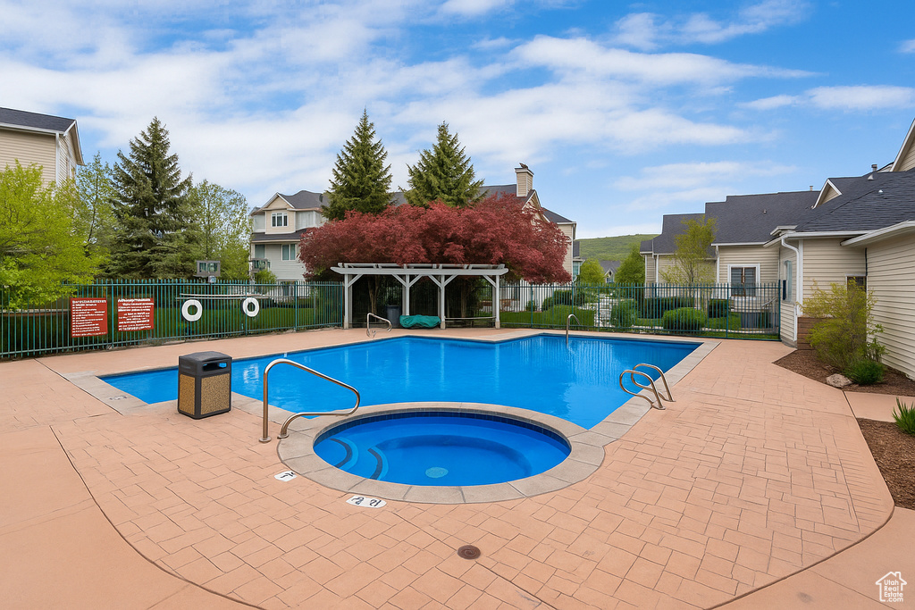Community pool with a community hot tub, a patio, and a pergola