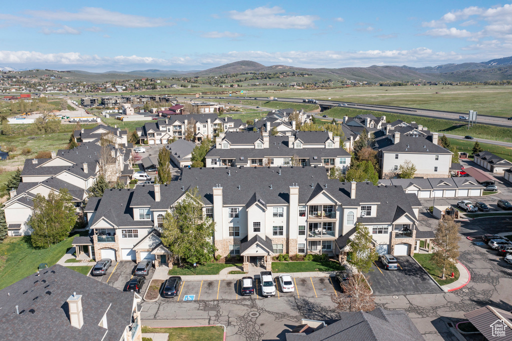 Aerial view of property and surrounding area with a mountainous background and nearby suburban area
