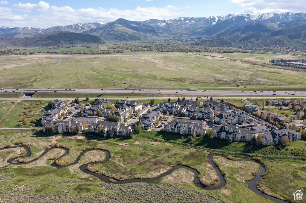 Aerial view of property and surrounding area featuring nearby suburban area and a mountainous background