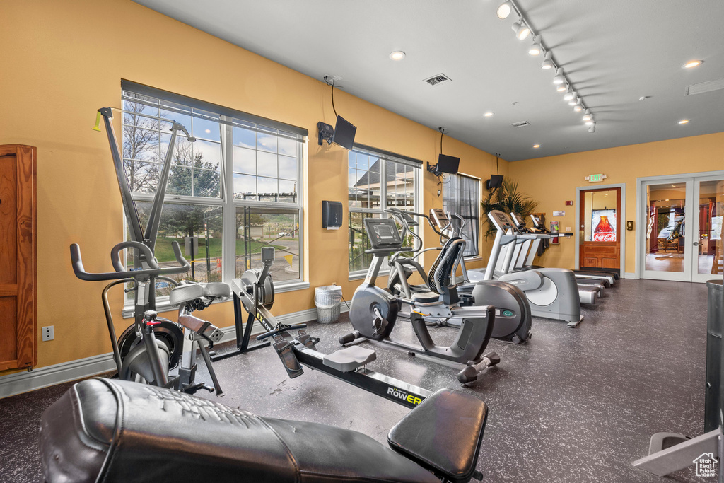 Gym featuring baseboards and rail lighting