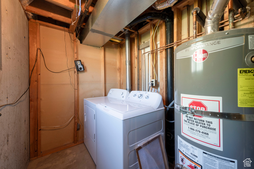 Washroom featuring strapped water heater and washing machine and clothes dryer