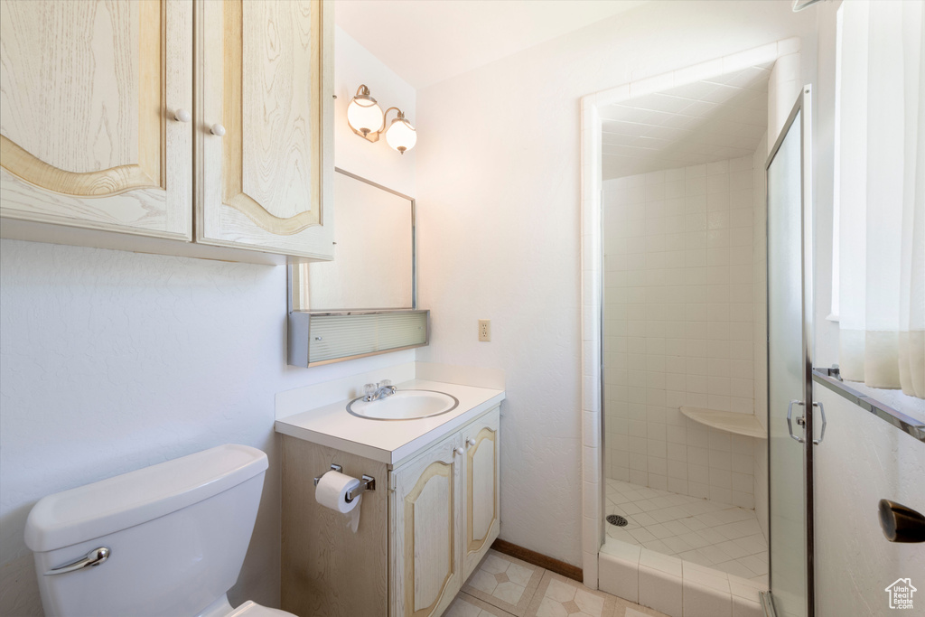 Full bathroom with a stall shower, toilet, and vanity