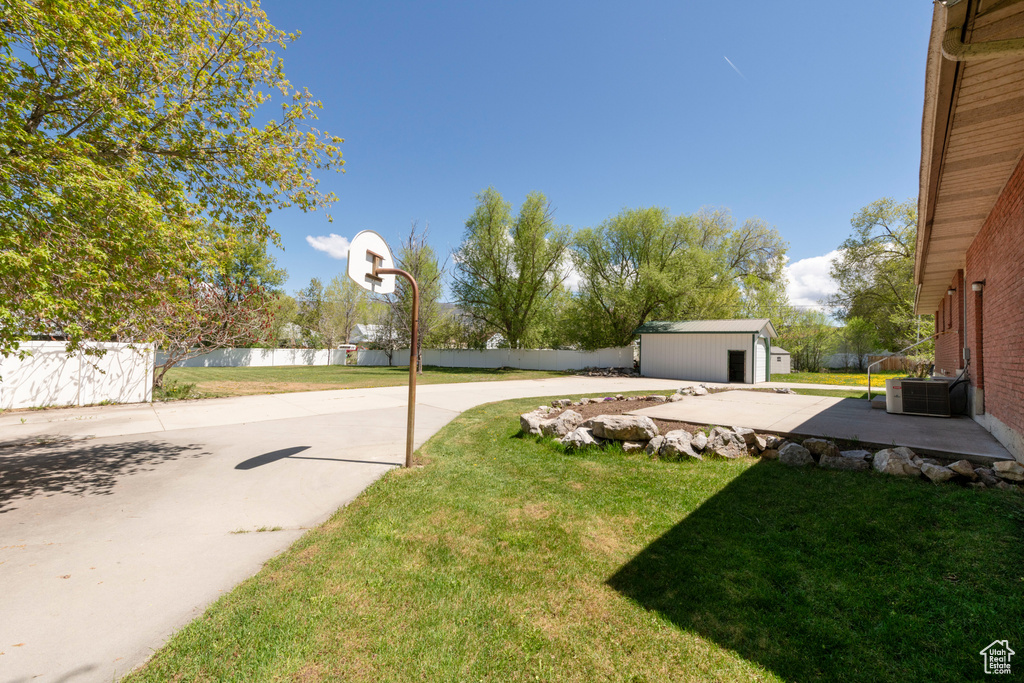View of yard with an outdoor structure and central AC unit