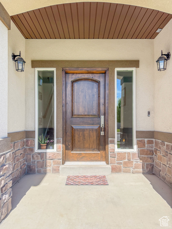 View of exterior entry featuring stucco siding and stone siding
