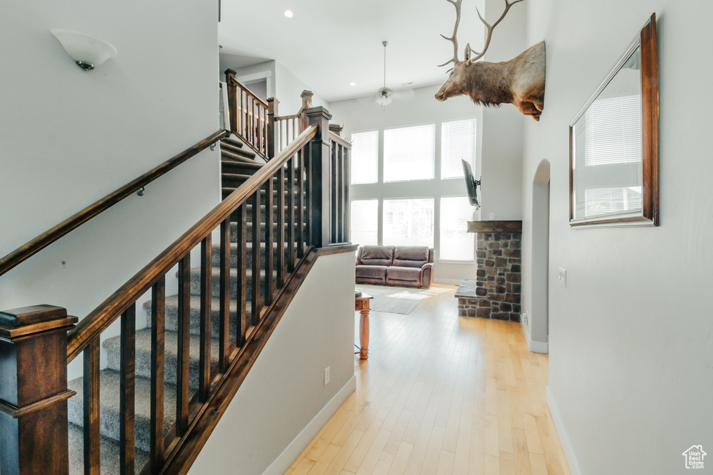Stairway featuring ceiling fan, arched walkways, recessed lighting, baseboards, and wood finished floors