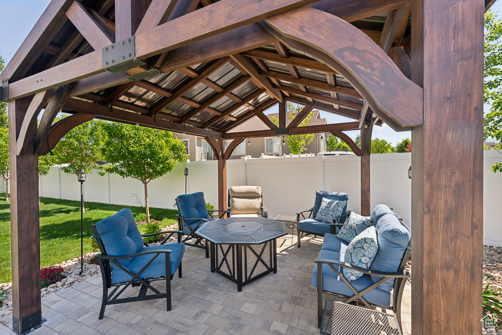Fenced backyard featuring a gazebo, an outdoor living space, and a patio