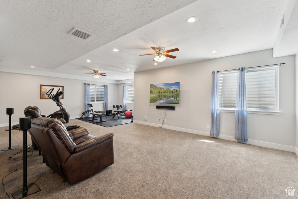 Carpeted living area featuring recessed lighting, ceiling fan, and baseboards
