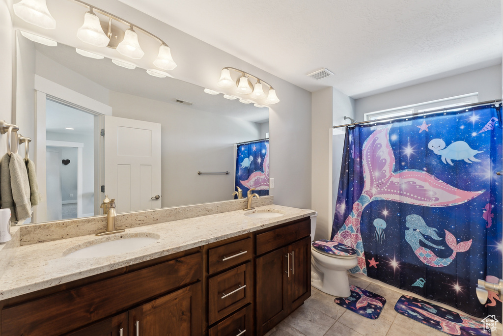 Full bathroom featuring tile patterned flooring, toilet, double vanity, and curtained shower