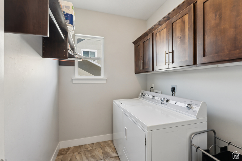 Laundry room with independent washer and dryer, cabinet space, and baseboards