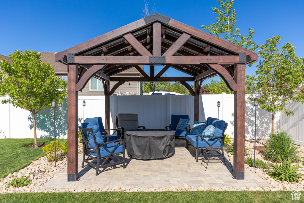 Fenced backyard featuring a gazebo, a patio, and a fire pit