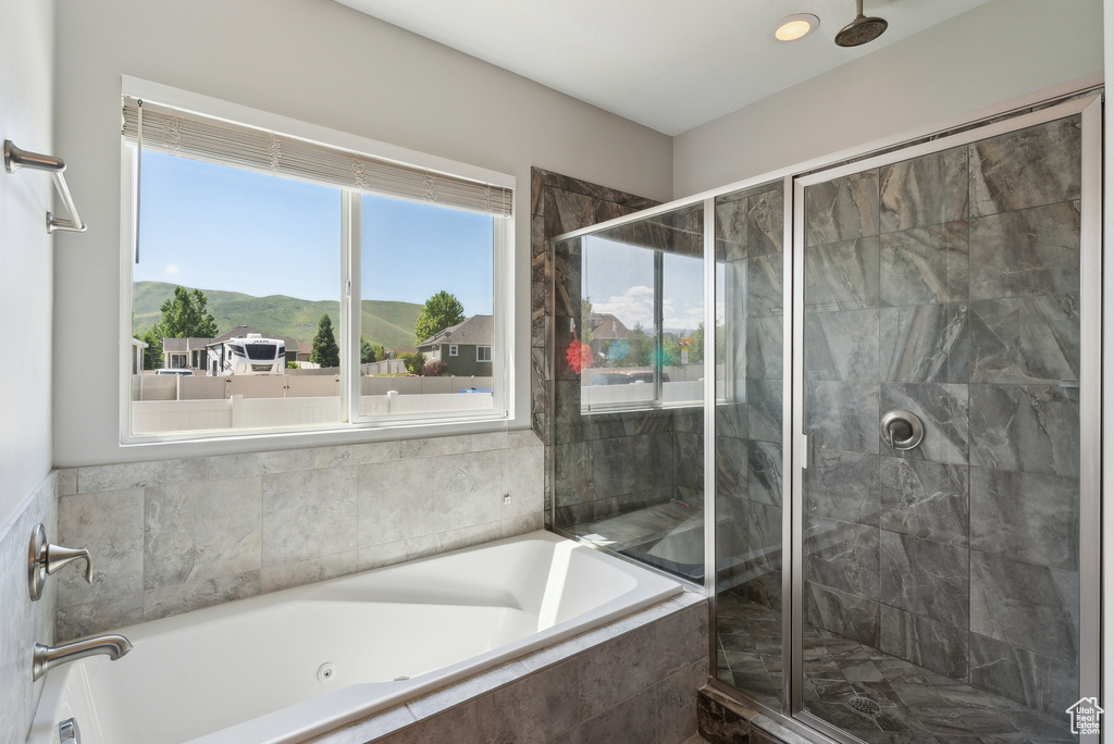 Bathroom with a whirlpool tub, a shower stall, and a mountain view