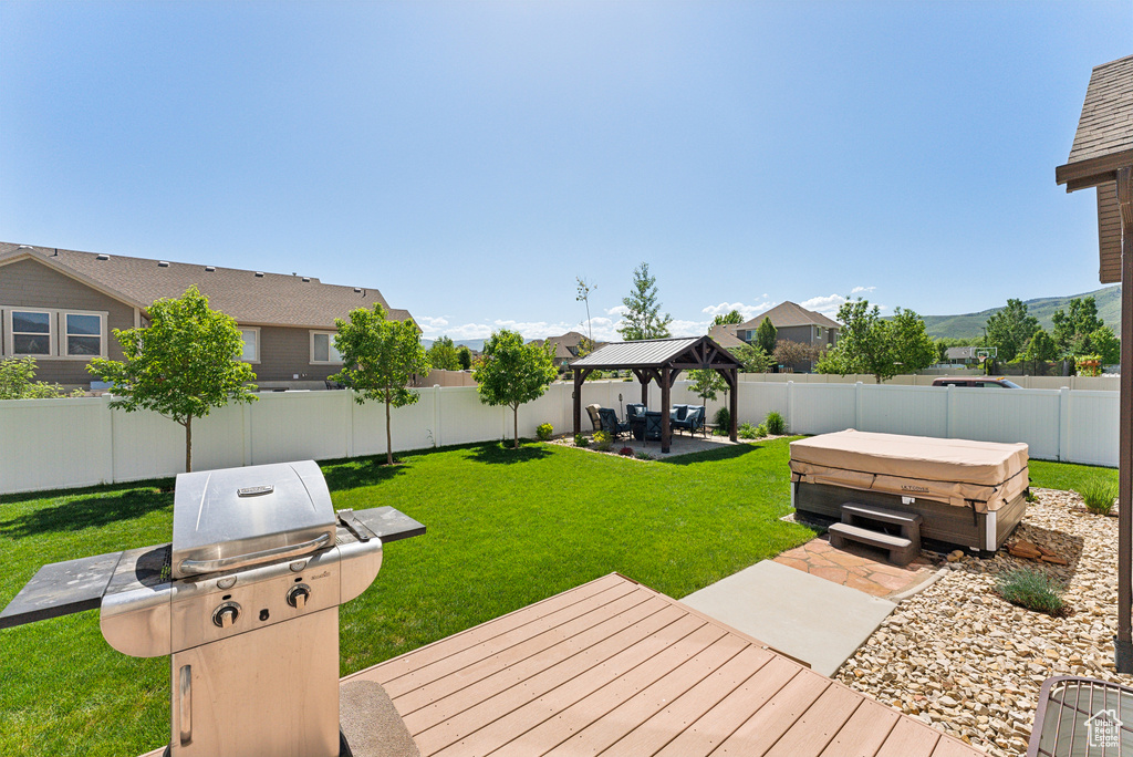 View of yard featuring a hot tub, a gazebo, a patio, a deck with mountain view, and a residential view