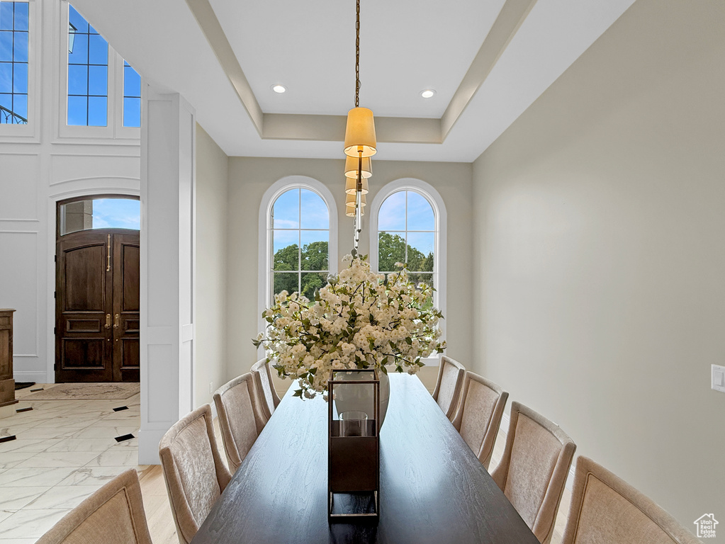 Dining space with marble finish flooring, recessed lighting, and a tray ceiling